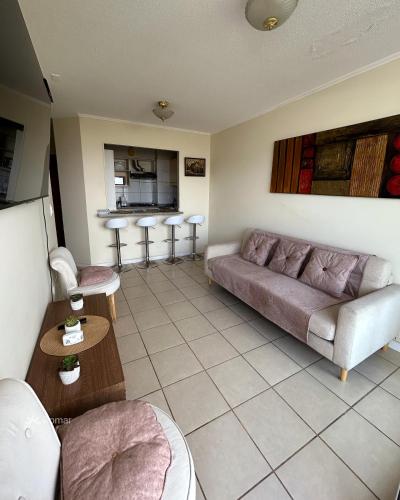 a living room with a couch and a table at Romar Departamentos Vista al Mar Costanera in Coquimbo