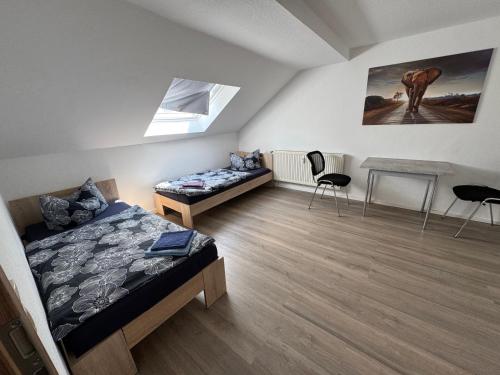 ゲーラにあるBüchner 50のベッド2台とテーブルと椅子のある寝室