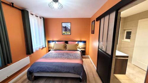 a small bedroom with orange walls and a bed at Appartement "Coeur de Ville" - parking privé - gare à 200m in Saverne