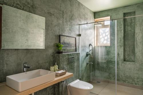 a bathroom with a sink and a shower and a toilet at Raina Villas Goa 6 bhk lux Pvt Pool in Arpora