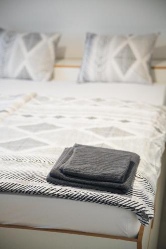 a black towel sitting on the end of a bed at Domeq in Komárov