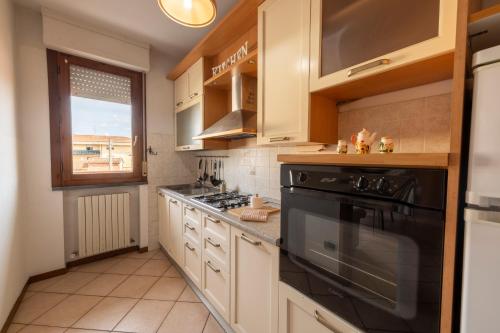 a kitchen with a black stove and a window at Cozy Corner near Lucca in Chiesina Uzzanese
