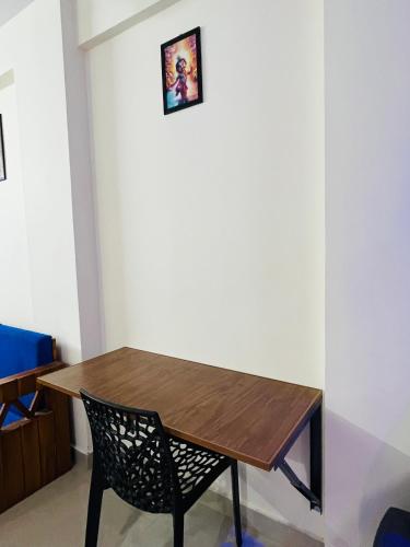 グルヴァイアールにある1 BHK flat at Guruvayur - Sooryamadhavam Apartments-only for pilgrimsの木製テーブルと椅子