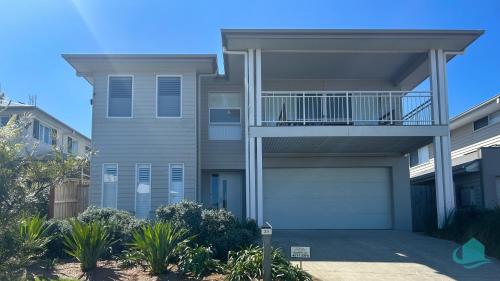 ein Mehrfamilienhaus mit Balkon und Garage in der Unterkunft The Sanctuary at Catherine Hill Bay in Catherine Hill Bay