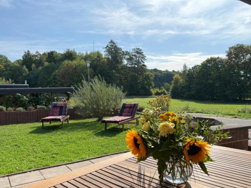 a vase of flowers on a table with two chairs at Ferienhaus Waldwinkel in Wrexen