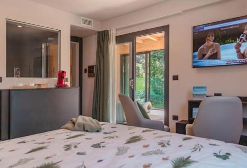 a bedroom with a bed and a tv on the wall at Camping Village Ekar Asiago in Asiago