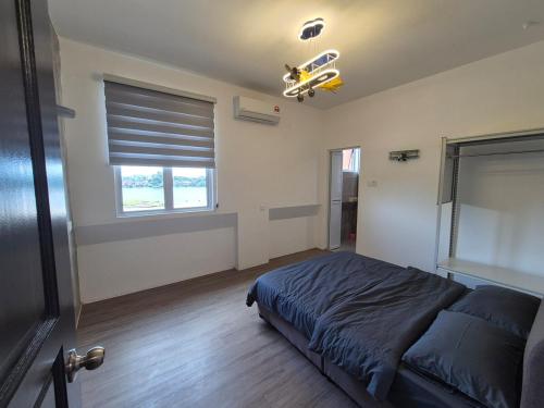 a bedroom with a bed and a window at Propeller Airplane Riverview Kuching Homestay in Kuching