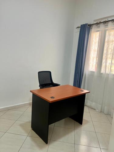 a desk with a chair in a room with a window at 3Bedroom Hilltop Home In Muyenga in Kampala