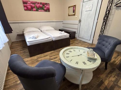 a room with a bed and a clock and chairs at Antonio Old Town Residence in Prešov