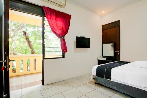 un dormitorio con una cama y una ventana en OYO 94632 Griya Cewang Syariah, en Bekasi