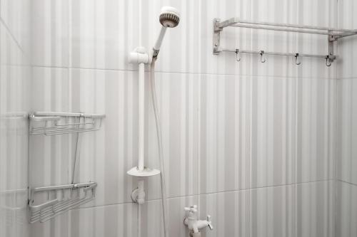 a shower with a shower head and a shower curtain at Homestay Nusa Indah 2 Syariah at Dieng 0 KM RedPartner in Dieng
