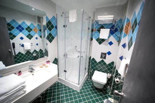a bathroom with a shower and a toilet and a sink at Funda Hotel in Trabzon
