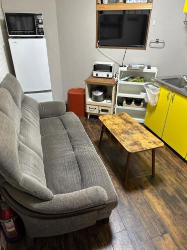 a living room with a couch and a table at Ryokoheya Awajikan in Osaka