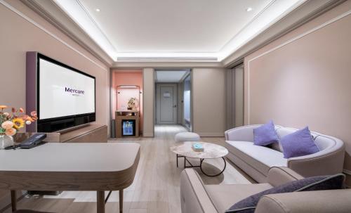 a living room with a couch and a tv at Mercure Guangzhou Baiyun International Airport - Airport Free Shuttle Bus in Huadu