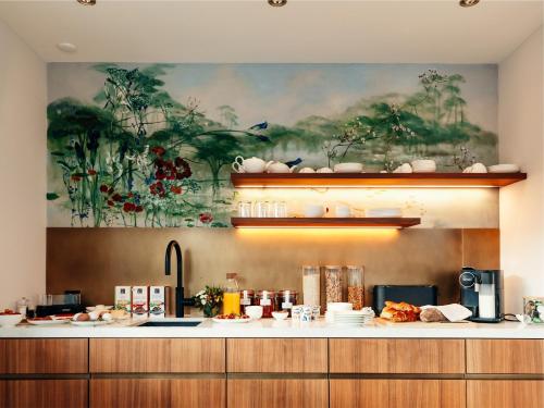 a kitchen with a large painting on the wall at Martin's Guesthouse in Basel
