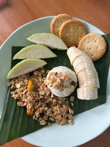 a plate of food with a banana and nuts at Mookda House Chinatown BKK near MRT Samyot in Khlong San