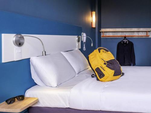 a yellow backpack sitting on a bed in a room at ibis budget Leme SP in Leme