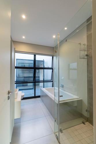 a bathroom with a shower and a sink and a tub at Thalia House in Johannesburg