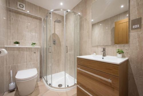 a bathroom with a shower and a toilet and a sink at Romford - Balcony - Outdoor Space - Parking Space in Romford