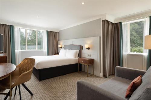 a hotel room with a bed and a table and a couch at DoubleTree by Hilton St. Anne's Manor in Bracknell