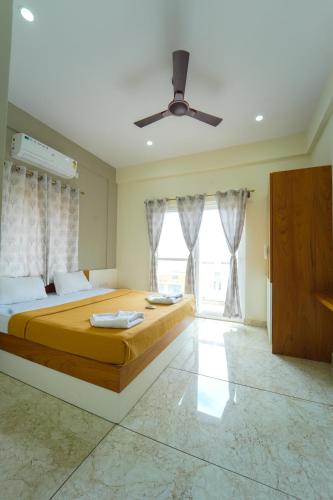 a bedroom with a large bed and a ceiling fan at Nandan Enclave in Mysore