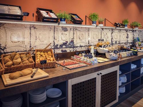 un buffet con pan y otros alimentos en una barra en Adagio Access Stuttgart Airport Messe, en Leinfelden-Echterdingen