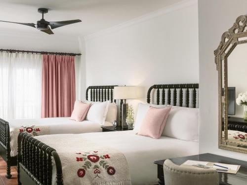 a hotel room with two beds and a mirror at Casa Faena Miami Beach in Miami Beach