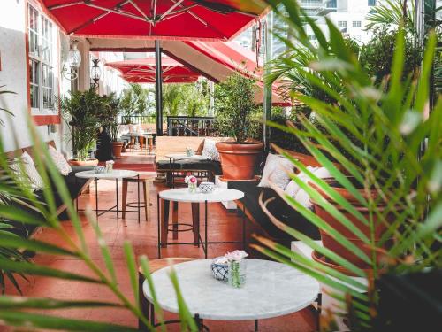 a patio with tables and chairs and umbrellas at Casa Faena Miami Beach in Miami Beach