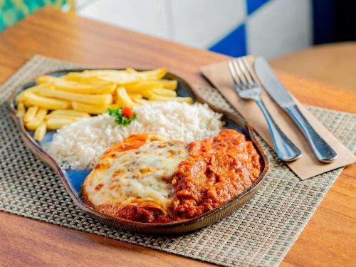 a plate of food with rice and dip and french fries at ibis Styles Sorocaba Santa Rosalia in Sorocaba