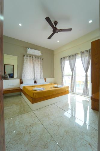a bedroom with a bed and a ceiling fan at Nandan Enclave in Mysore