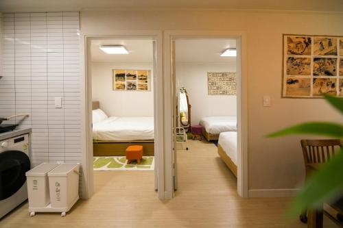 a room with two beds and a door to a bedroom at wonjong stay 101 김포공항 in Pakkosi