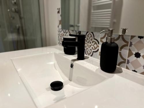 a bathroom sink with two black bottles on it at Studio des bains in Aix-les-Bains