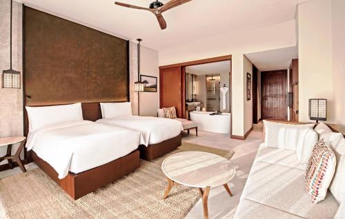 a bedroom with two beds and a living room at Alila Hinu Bay Salalah Mirbat in Salalah