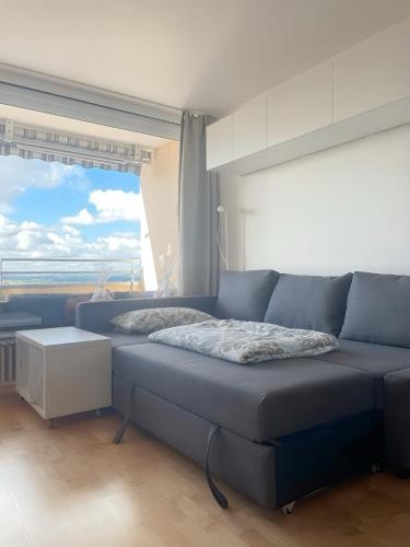 a blue couch in a room with a large window at Kerzen Boutique in Bad Salzuflen