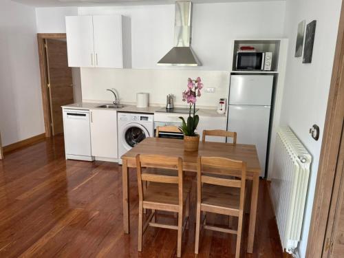 a kitchen with a table and chairs and a refrigerator at Apartamentos Pirineo in Isaba