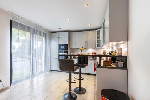 a kitchen with white cabinets and a bar stool at Wohnung mit 3 Schlafzimmern in Solingen