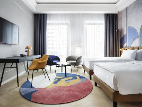 a hotel room with two beds and a desk at Mercure Krakow Fabryczna City in Kraków