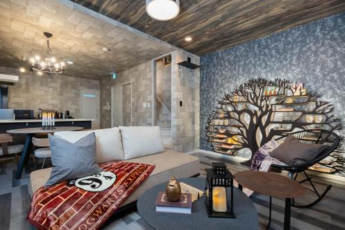 a living room with a couch and a tree mural at JAPAVISTA Enchant in Osaka