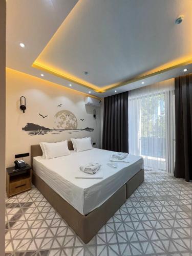 a bedroom with a large bed and a large window at Rich Land Hotel in Samarkand
