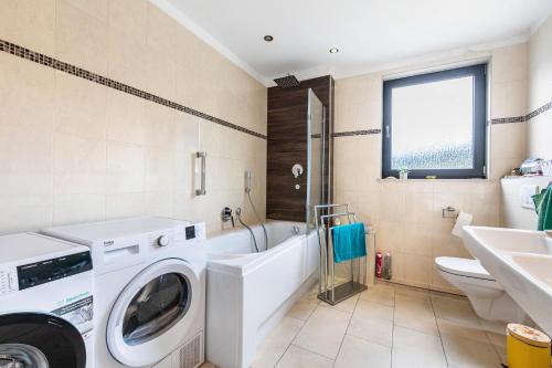 a bathroom with a washing machine and a sink at Wohnung mit 3 Schlafzimmern in Solingen