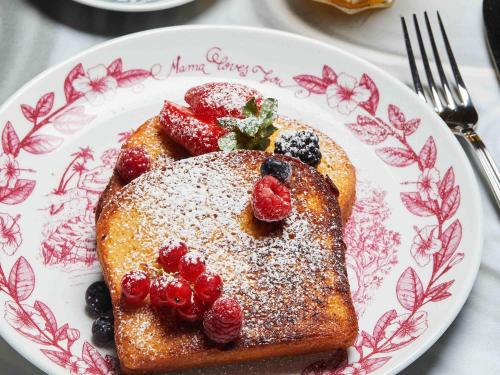 a plate of french toast with berries and powdered sugar at Mama Shelter Roma in Rome