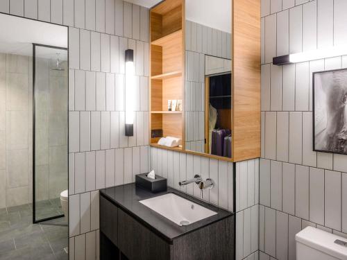a bathroom with a sink and a mirror at Mövenpick Hotel Hobart in Hobart