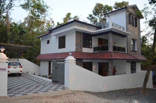 a house with a car parked in front of it at Apollo Cottage in Tiruvankod