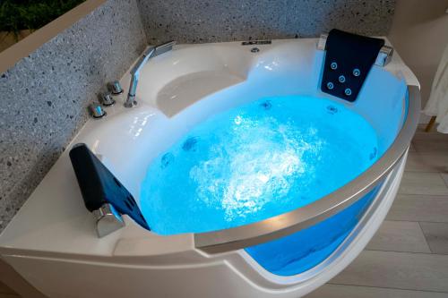 a jacuzzi tub with blue water in it at Suite sensuelle et balnéothérapie in Nemours