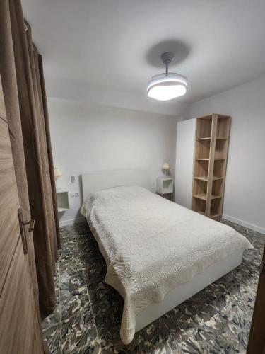 a bedroom with a bed in a white room at Apartamento cerca de la playa in Cullera