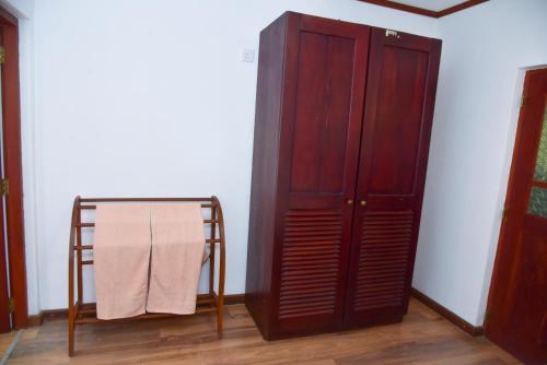 a wooden cabinet next to a table and a towel at Villa Thotiya in Aluthgama