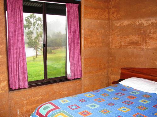 a bedroom with a bed and a window at Pemberton Lake View Chalets in Pemberton