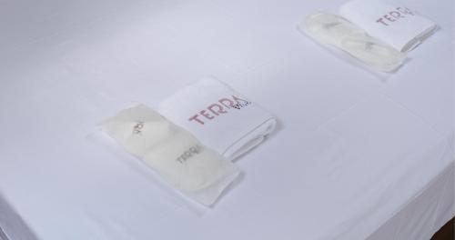 three white towels sitting on a white table at Terra Viva Villa's in Erenköy