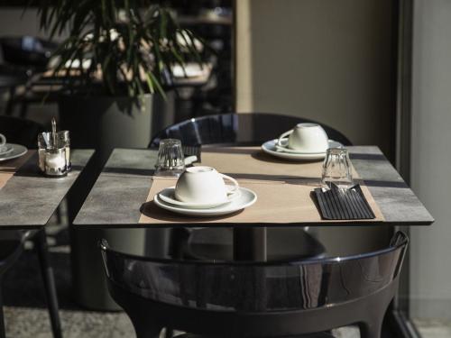a table with plates and glasses on top of it at Mercure Belfort Centre in Belfort