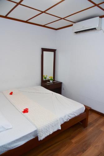 a bedroom with a white bed and a mirror at Villa Thotiya in Aluthgama